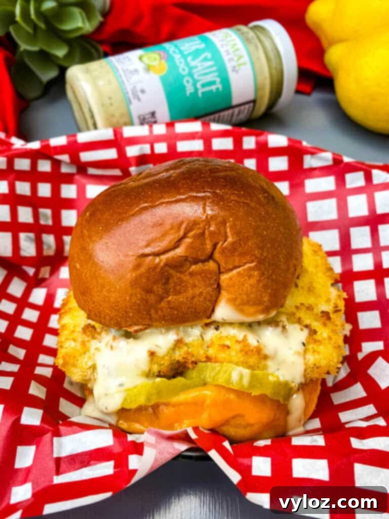 Crispy Air Fryer Fish Sandwich 2 Crispy Air Fryer Fish Sandwich with melted cheese and tartar sauce on a brioche bun