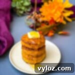 Deliciously Easy Sweet Potato Biscuits 15 Sweet potato biscuits on a plate with butter drizzled in honey