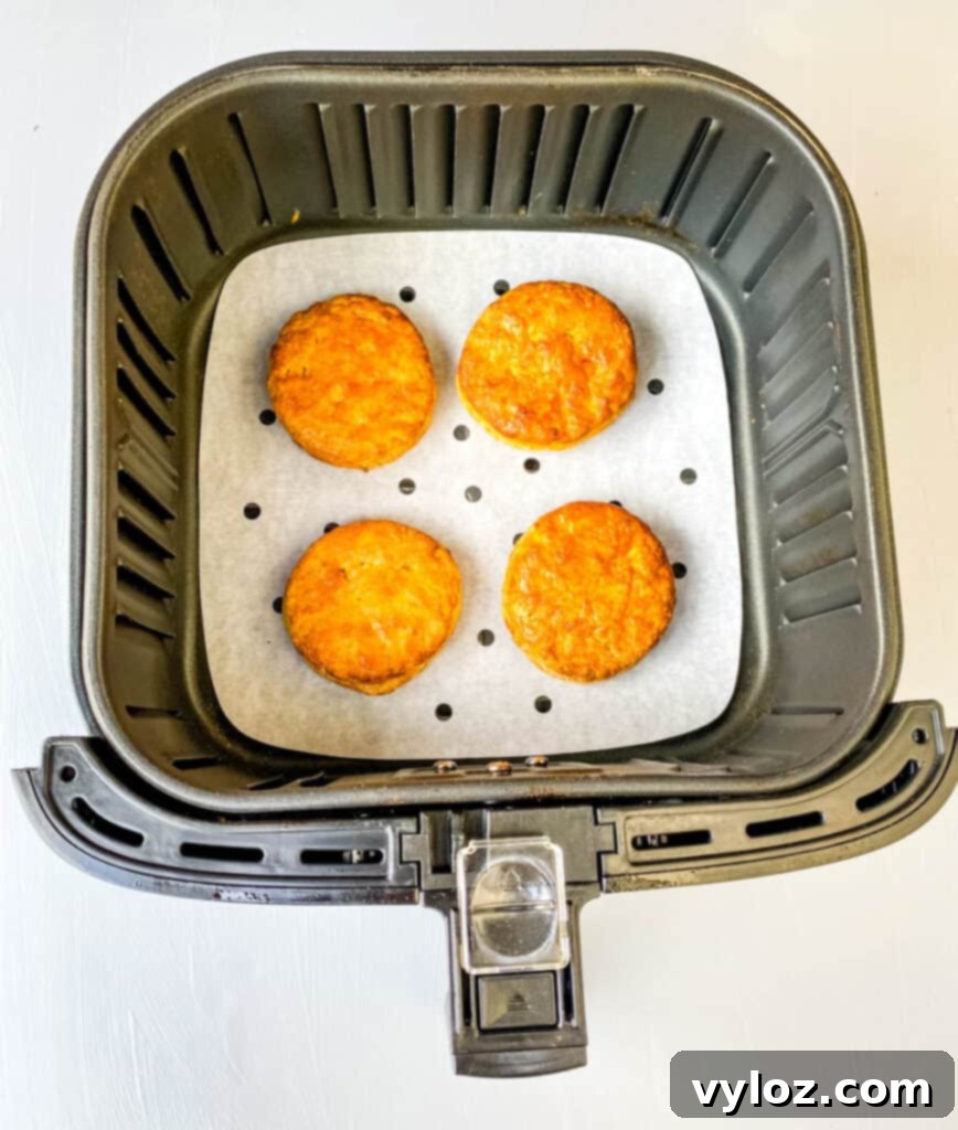 Deliciously Easy Sweet Potato Biscuits 10 Golden sweet potato biscuits baking to perfection in an air fryer basket.