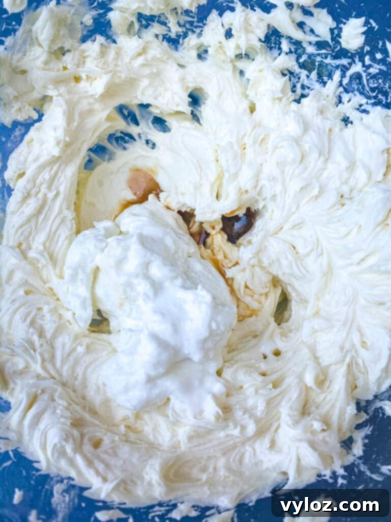 Heavy cream being whipped to stiff peaks in a glass bowl