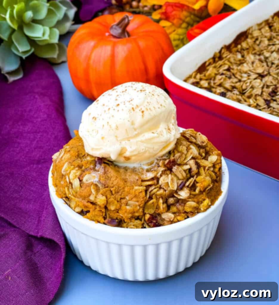 Healthy sugar free pumpkin crisp in a white bowl, elegantly topped with a scoop of creamy vanilla ice cream, ready to be enjoyed as a delightful dessert or a wholesome breakfast.