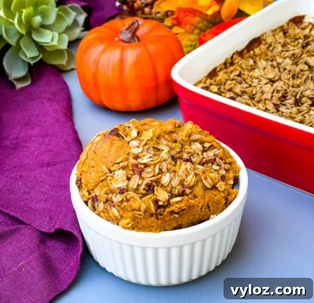 A perfectly portioned slice of healthy sugar free pumpkin crisp, showcasing its vibrant orange filling, crunchy oat topping, and the delightful texture, presented on a pristine white plate, ready to be savored.