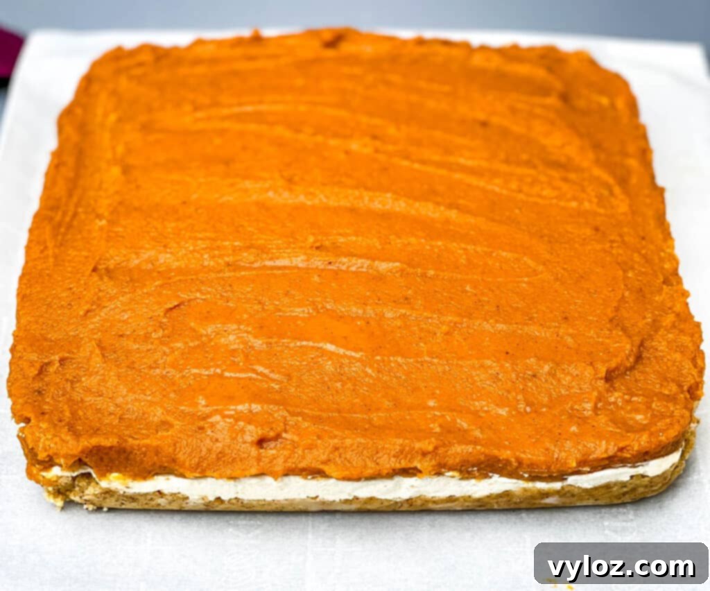 pumpkin cheesecake bars on parchment paper