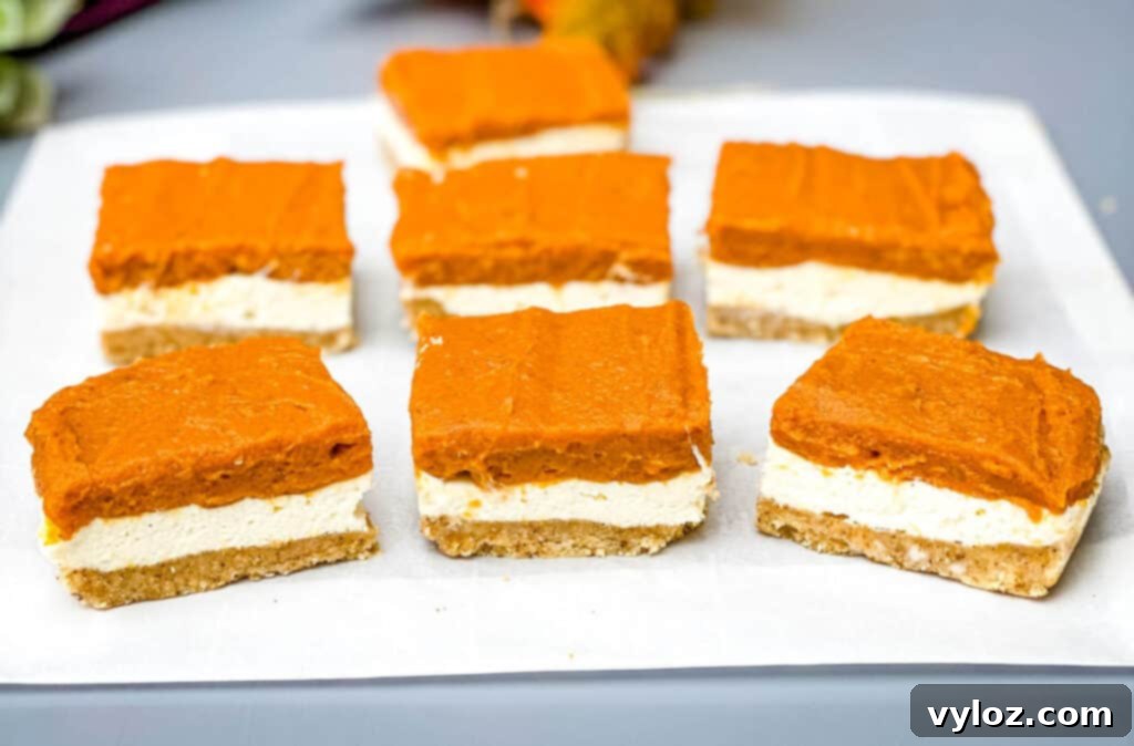 pumpkin cheesecake bars on parchment paper