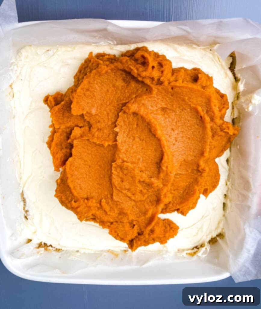 pumpkin cheesecake bars in red baking dish