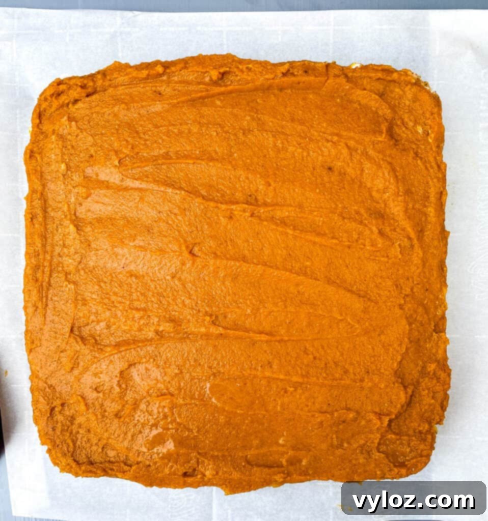 pumpkin cheesecake bars on parchment paper