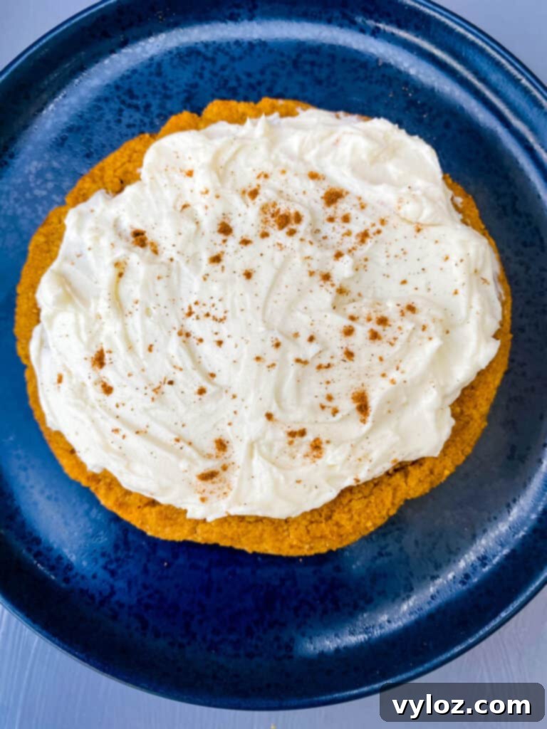Guilt-Free Pumpkin Spice Cookies 16 keto pumpkin cookies with cream cheese frosting and cinnamon on a blue plate