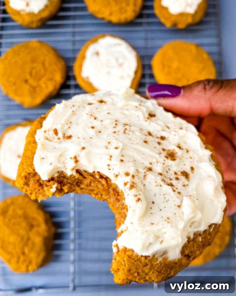Guilt-Free Pumpkin Spice Cookies 17 person holding keto pumpkin cookie with icing