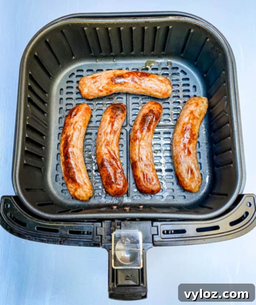perfectly cooked bratwurst in an air fryer basket
