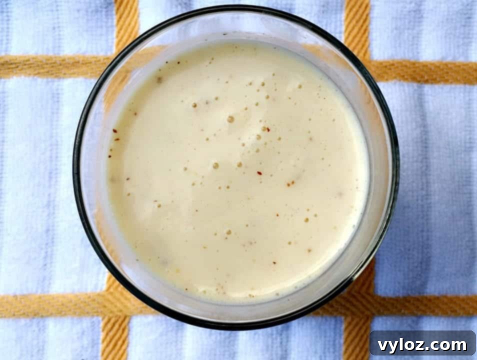 A person happily drinking a Butter Pecan Protein Smoothie in a natural light setting.