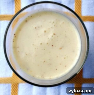 Butter Pecan Ice Cream Dessert Protein Smoothie in a glass, with a spoon.