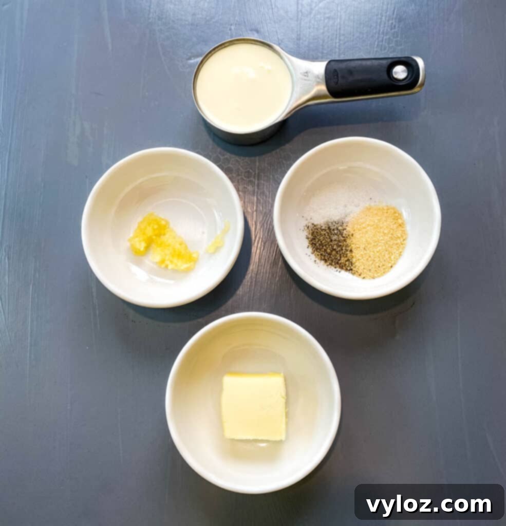 heavy cream, garlic, seasoning, and butter in separate bowls on a flat surface