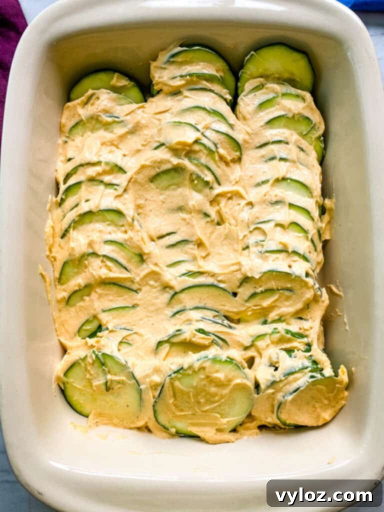 unbaked zucchini au gratin scalloped potatoes in a red baking dish