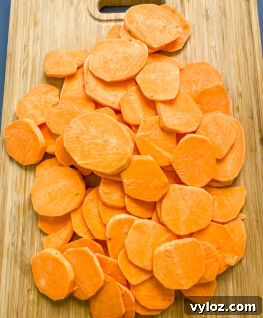 raw and sliced round sweet potatoes on a bamboo cutting board