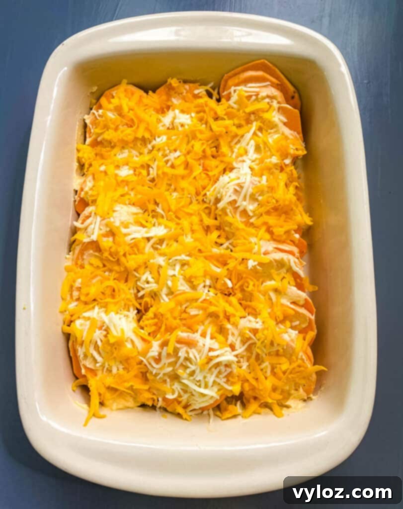 uncooked au gratin sweet potatoes in a red baking dish