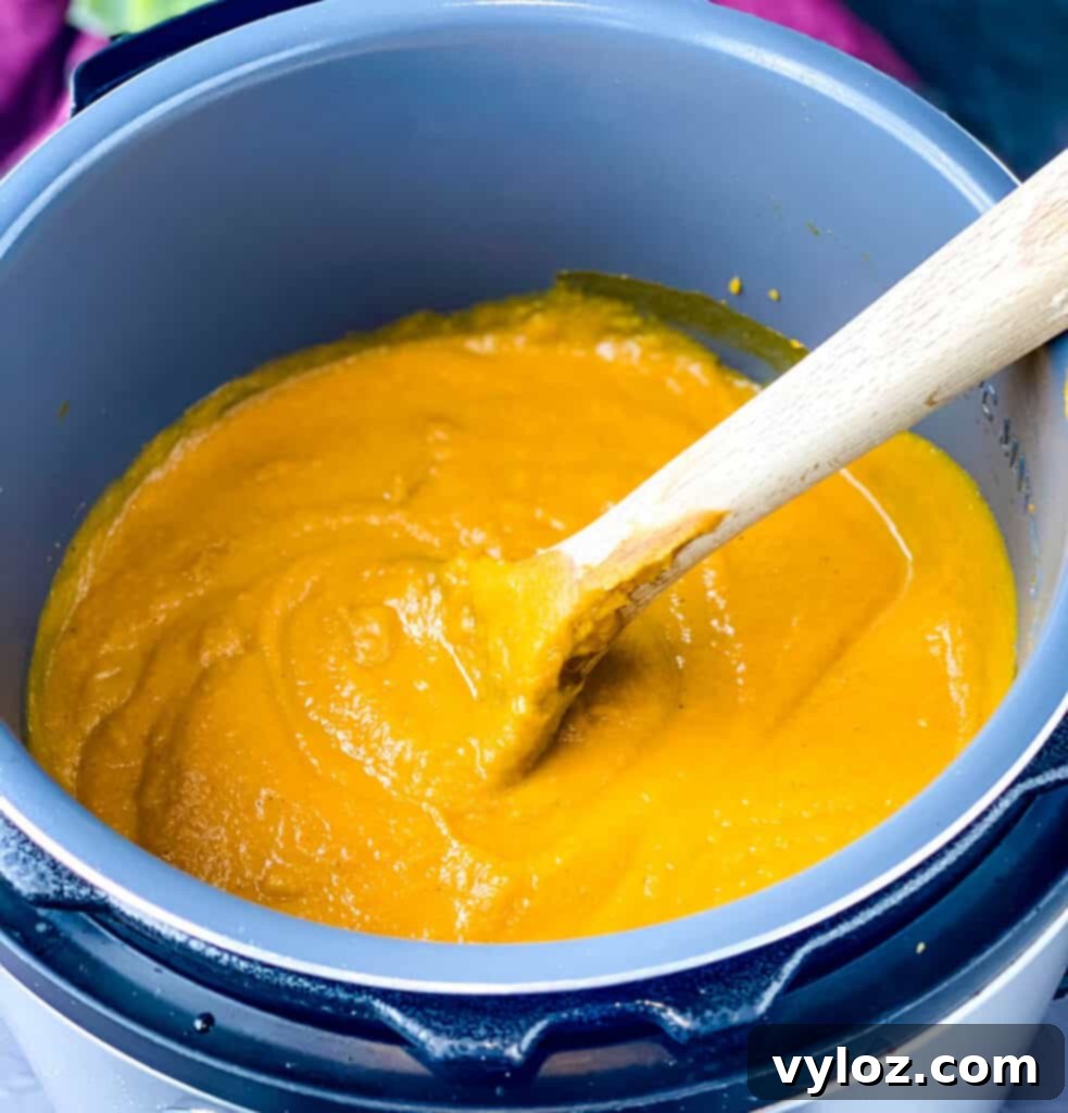 a wooden spoon in a pot of sweet potato soup