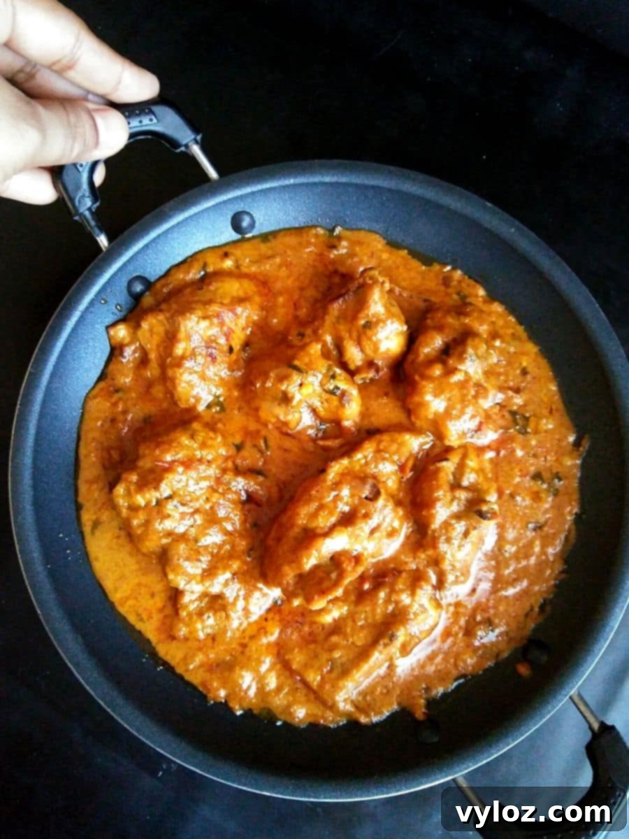 Delicious Chicken Changezi, a creamy Indian chicken curry, garnished with fresh herbs in a nonstick pan, ready to serve.