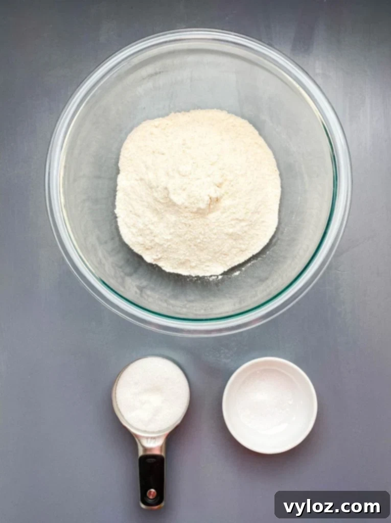 self rising cornmeal, sweetener, and salt in separate bowls on a flat surface
