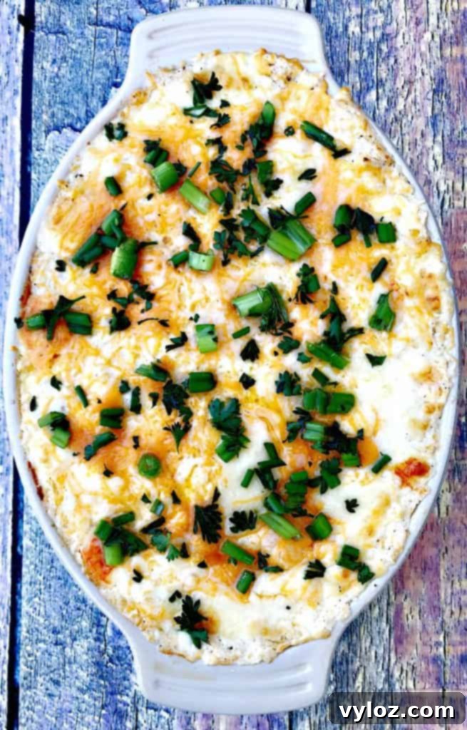 hot crab dip in a baking dish with green onions