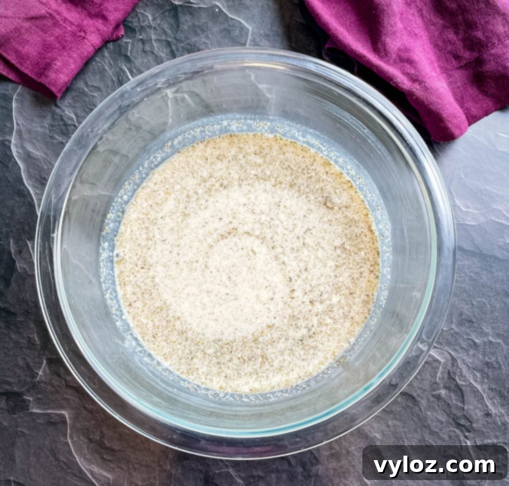 A smooth, creamy mixture of milk, flour, and aromatic seasonings artfully arranged in a glass bowl, showcasing the ingredients before blending into soup.