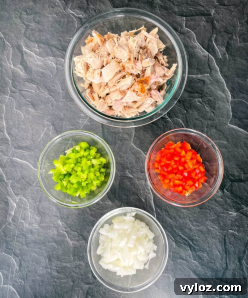 Thanksgiving turkey, chopped green pepper, chopped red peppers, and chopped onions on a flat surface