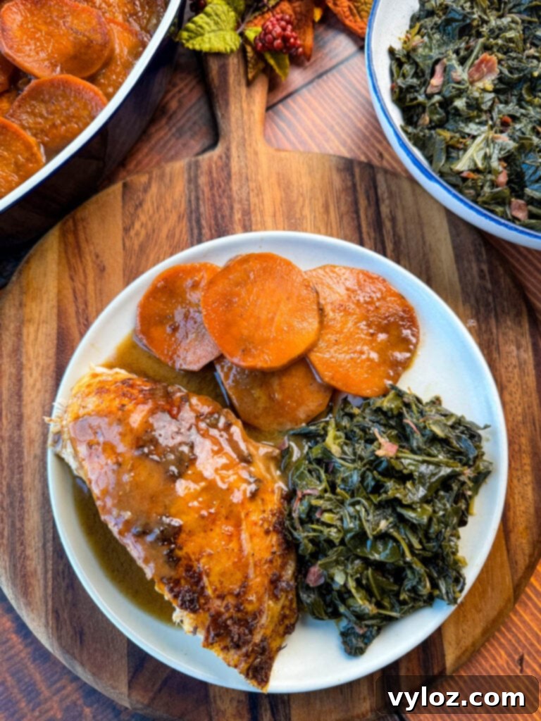 Cajun turkey on a plate with gravy, collard greens, and candied sweet potatoes