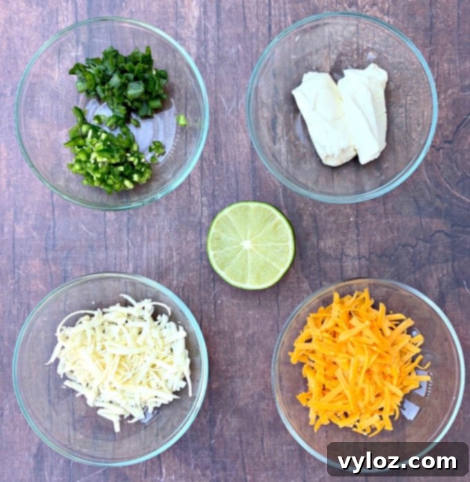 ingredients for keto low carb jalapeno popper chicken including chopped jalapeno, softened cream cheese, shredded cheese, and fresh lime