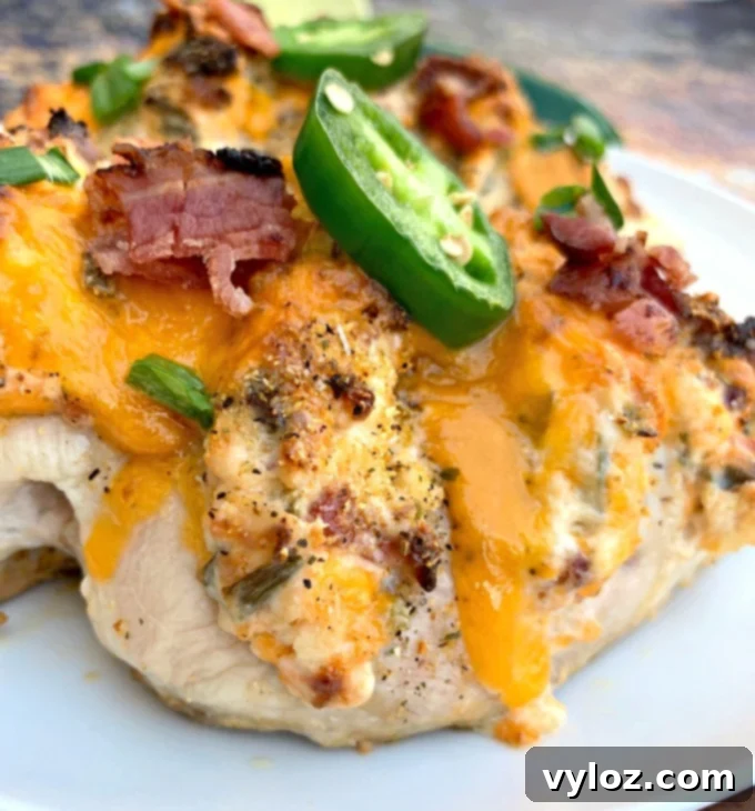 keto low carb jalapeno popper hasselback chicken on a white plate, ready to serve