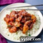 keto low carb orange chicken on a white plate with sesame seeds