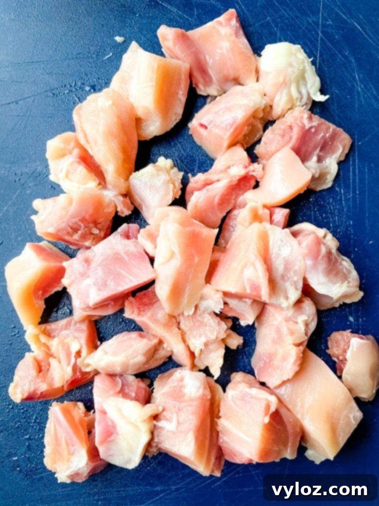 raw chicken thighs sliced on a cutting board