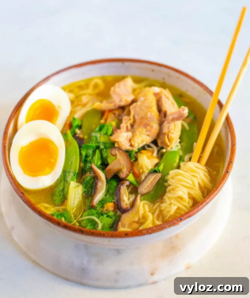 Instant Pot chicken ramen in a bowl with chopsticks, garnished with a soft-boiled egg and green onions.