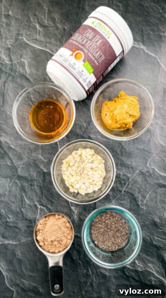 Individual ingredients for Chai Almond Butter Protein Balls: honey, almond butter, rolled oats, chia seeds, and chai collagen, laid out in separate bowls.