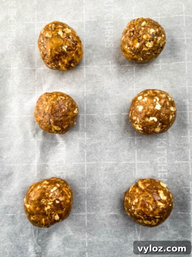Neatly arranged Chai Almond Butter Protein Balls on parchment paper, ready for chilling or storage.