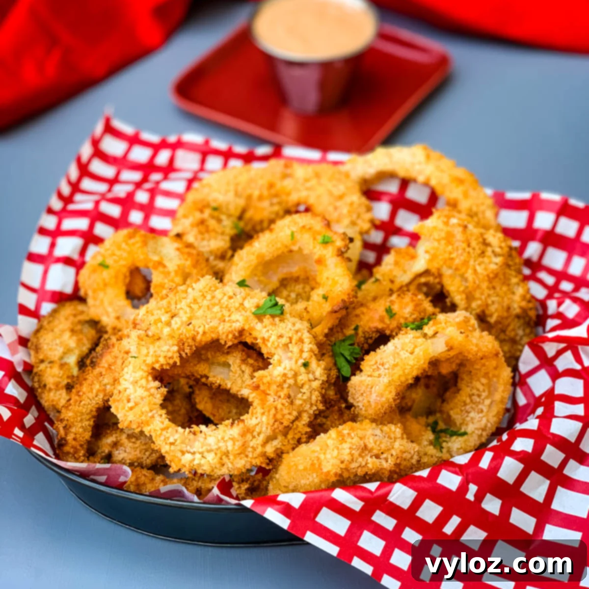 30 Quick and Delicious Air Fryer Appetizers 4 Platter of homemade crispy air fryer onion rings with a side of dipping sauce.