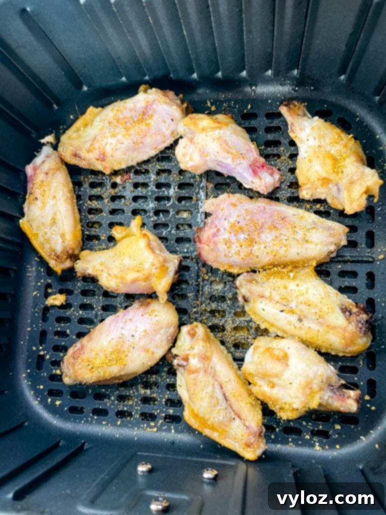 Seasoned chicken wings cooking in the air fryer