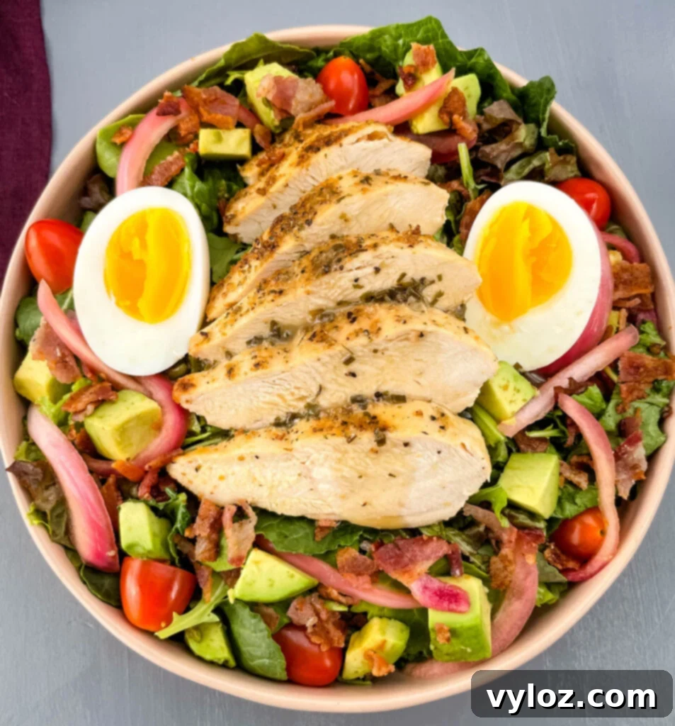 Large bowl of Green Goddess Cobb Salad with chicken, eggs, avocado, bacon, and dressing
