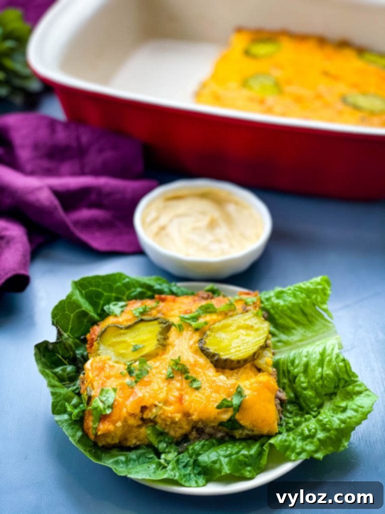 Big Mac Bake 2 A delectable slice of Big Mac Casserole on a bed of fresh lettuce, generously drizzled with Big Mac Sauce, highlighting its rich textures and vibrant colors.