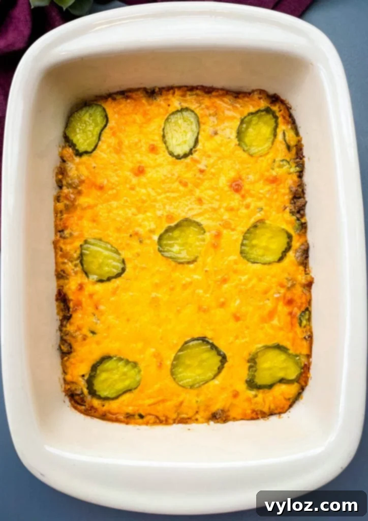 Big Mac Bake 11 The baked Big Mac Casserole still in its baking dish, garnished with fresh pickle slices on top, ready to be served as a satisfying, low-carb meal.