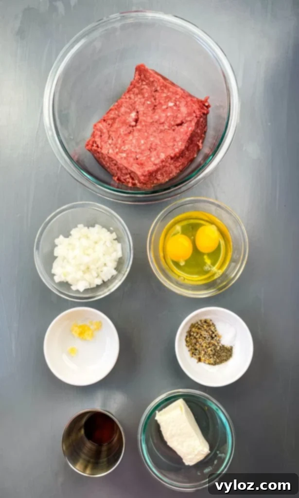 Big Mac Bake 3 A vibrant flat lay shot of essential Big Mac Casserole ingredients in individual glass bowls: ground beef, finely chopped onions, raw eggs, softened cream cheese, minced garlic, and a selection of savory seasonings.