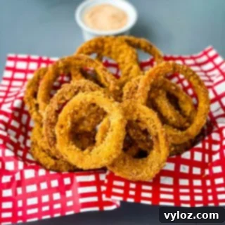 Crispy Keto Low-Carb Onion Rings 11 A basket filled with golden-brown, crispy keto low-carb onion rings, perfect as an appetizer or side.