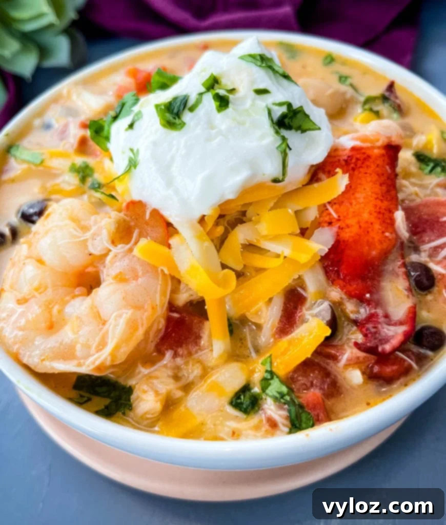 A tempting bowl of creamy seafood chili with shrimp and lobster, perfectly garnished and ready to enjoy.