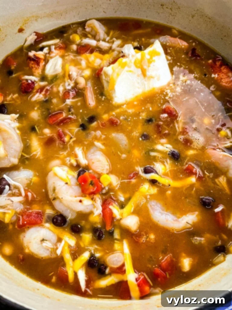 Rich and hearty seafood chili simmering gently in a vibrant red Dutch oven, releasing aromatic steam.