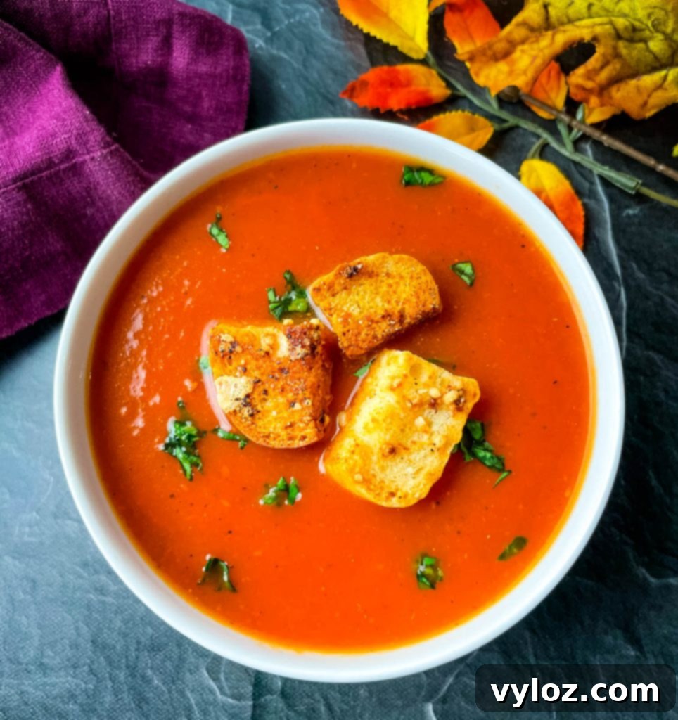Instant Pot tomato soup in a white bowl, garnished with fresh basil