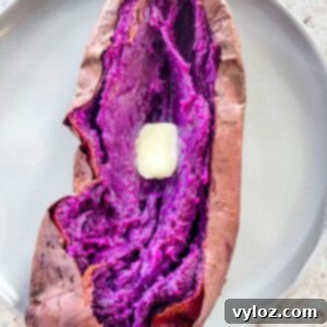 Stokes purple sweet potato fully cooked and sliced open on a plate with butter