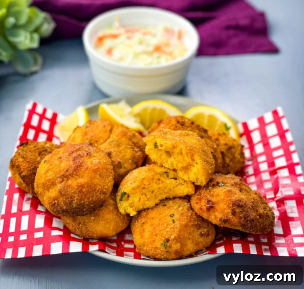 air fryer hushpuppies on a plate with fried fish and coleslaw