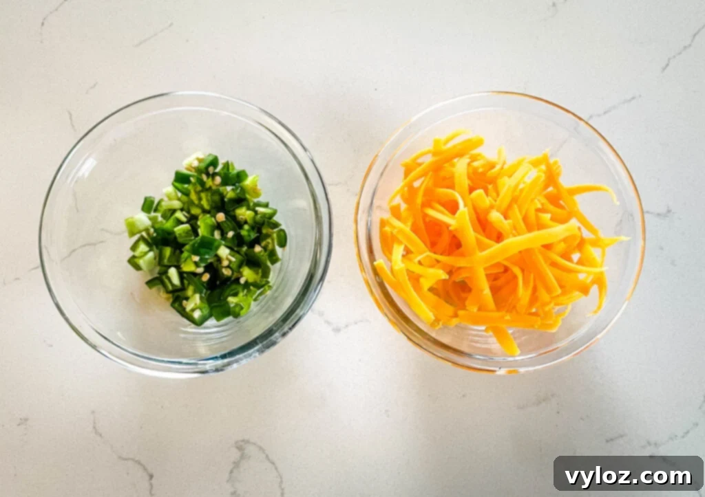 chopped jalapenos and shredded cheddar in separate glas bowls