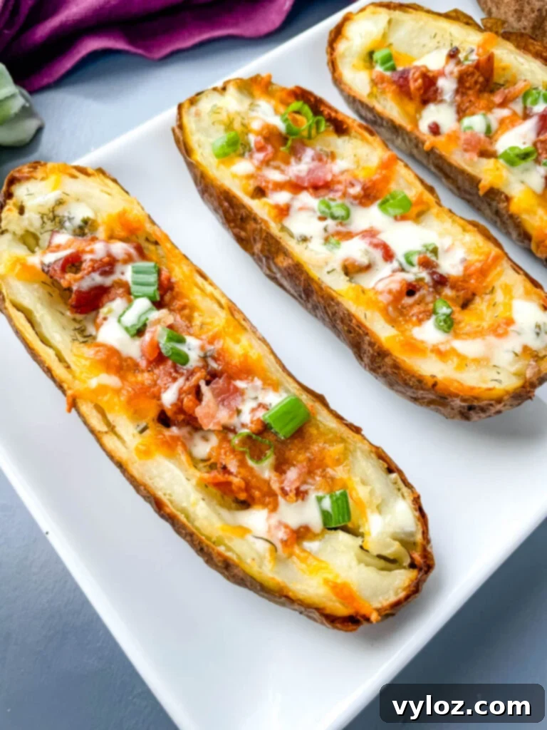 Air fryer potato skins on a plate, garnished with bacon and green onions