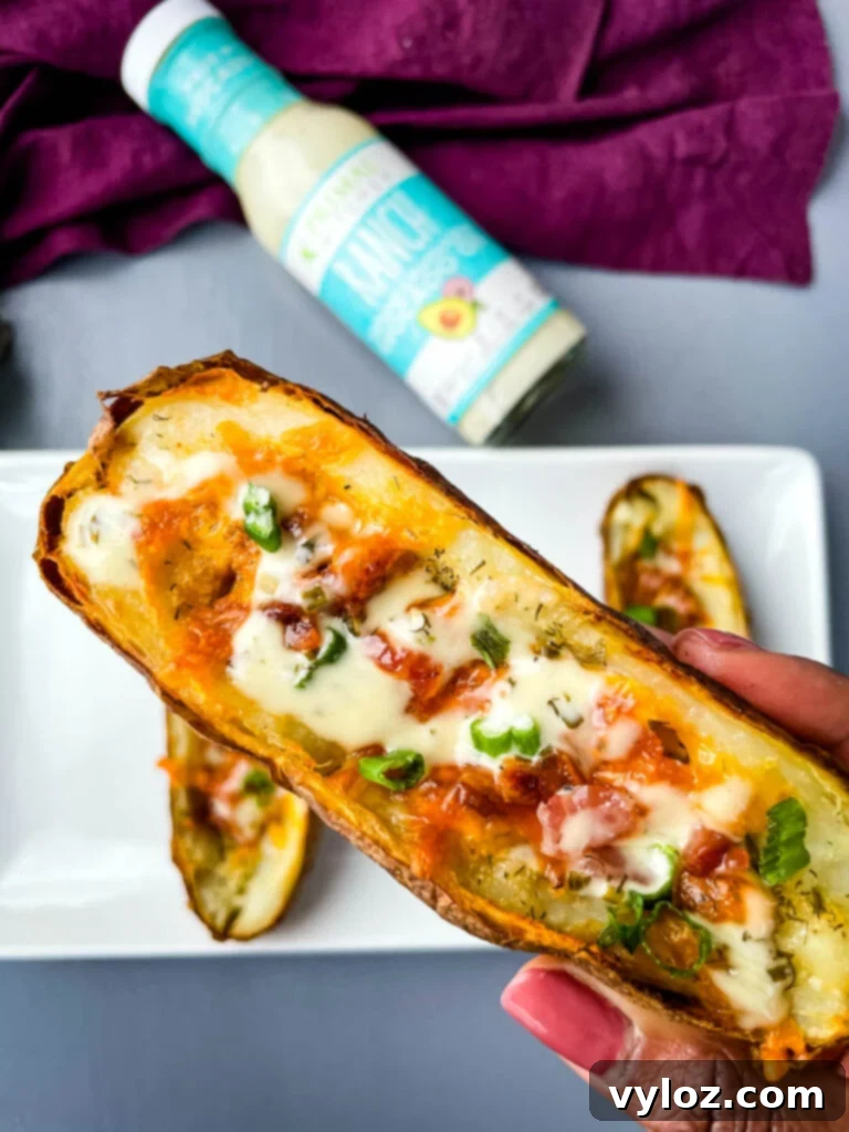 Person holding a finished Air Fryer Potato Skin with ranch drizzle