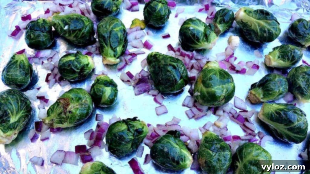 Overhead shot of freshly roasted Brussels sprouts on a dark baking sheet, glistening with balsamic