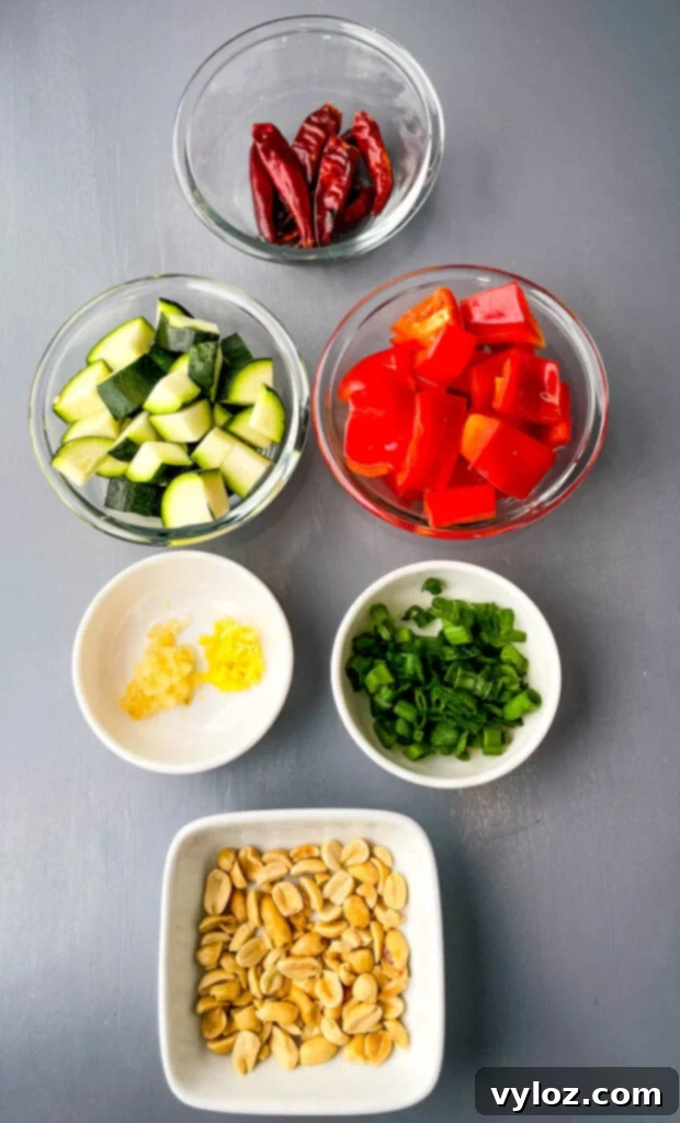 Panda Express style Kung Pao Chicken on a white plate with chopsticks.
